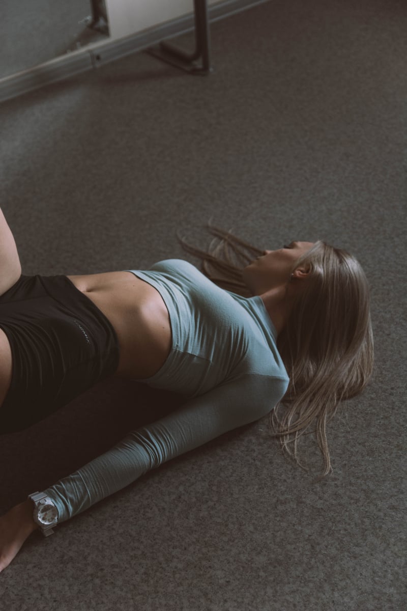 Woman in Gray Tank Top and Gray Leggings Lying on Floor